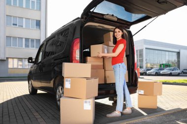 Kurye teslimat minibüsünden paket alıyor.