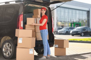 Kurye teslimat minibüsünden paket alıyor.