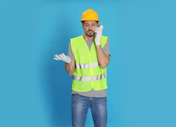 Ingeniero Industrial Masculino Uniforme Hablando Por Teléfono Contra Fondo Azul —  Fotos de Stock