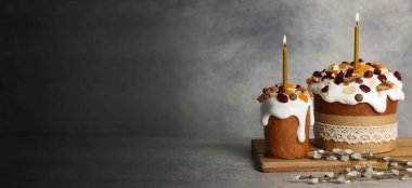 Tasty Easter cakes and pussy willow branches on grey table, space for text. Banner design
