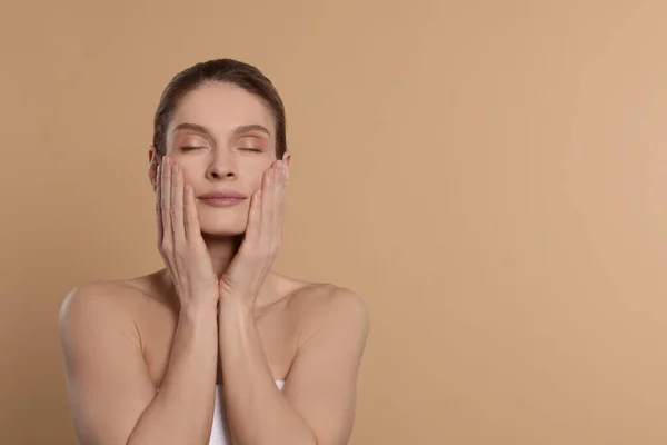 Woman Massaging Her Face Beige Background Space Text — Stok Foto