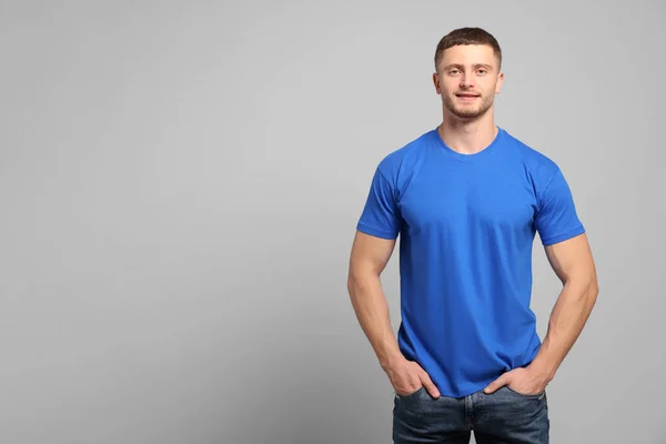 穿着浅灰色背景的蓝色T恤的男人 用于设计的模型 — 图库照片