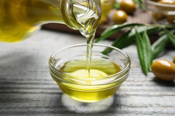 Pouring Olive Oil Bowl Wooden Table Closeup Healthy Cooking — Fotografia de Stock