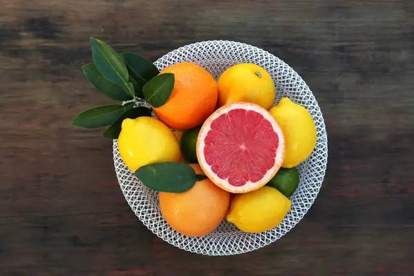 Bowl Different Citrus Fruits Leaves Wooden Table Top View — Stockfoto