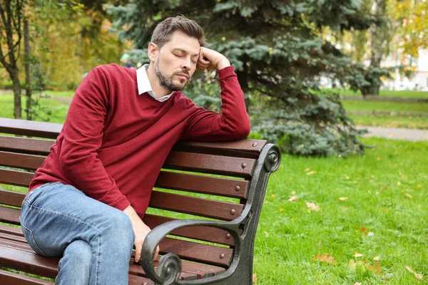 疲れた男が美しい緑の公園のベンチで寝ている テキストのスペース — ストック写真