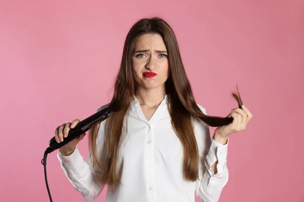 Aufgebrachte Junge Frau Mit Abgeflachtem Bügeleisen Auf Hellrosa Hintergrund Haarschäden — Stockfoto