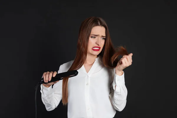 Gestresste Junge Frau Mit Abgeflachtem Eisen Auf Schwarzem Hintergrund Haarschäden — Stockfoto