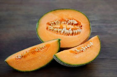 Tasty orange ripe melons on wooden table