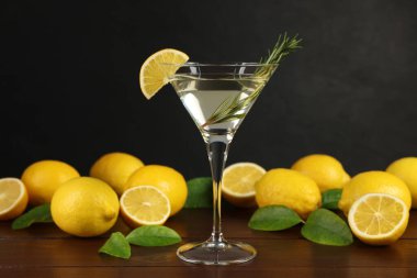 Limon dilimli martini kokteyli, biberiye ve ahşap masada taze meyve.