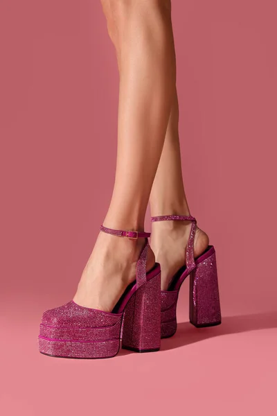 Woman wearing high heeled shoes with platform and square toes on pink background, closeup