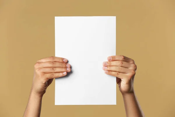 Man Holding Sheet Paper Beige Background Closeup Mockup Design — Stock fotografie