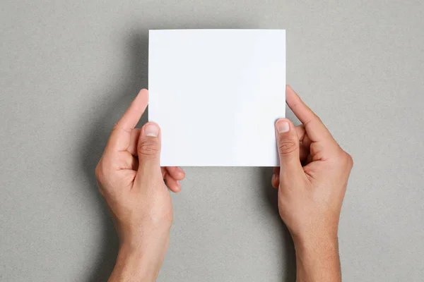 Man Holding Sheet Paper Grey Background Closeup Mockup Design — 图库照片