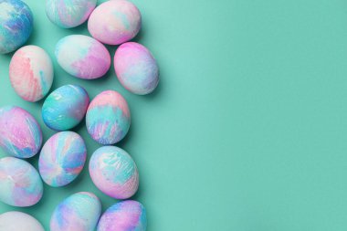Turkuaz arka planda birçok süslü Paskalya yumurtası, düzlük. Metin için boşluk
