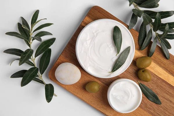 stock image Flat lay composition with jars of cream and olives on white background