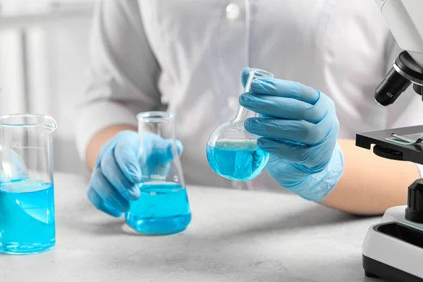 Científico Con Frascos Líquido Azul Claro Mesa Blanca Laboratorio Primer —  Fotos de Stock