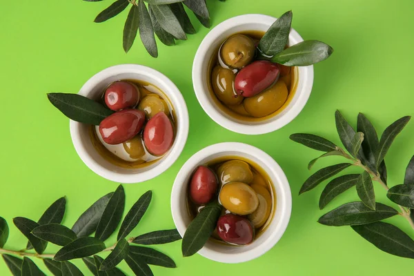 Bowls Different Ripe Olives Leaves Light Green Background Flat Lay — Stock Photo, Image