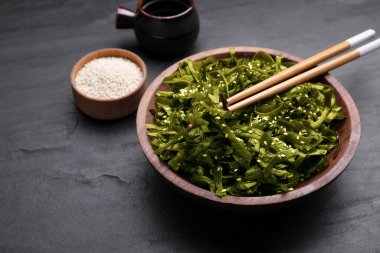 Fresh laminaria (kelp) seaweed served on black table