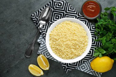 Tasty couscous and ingredients on grey table, flat lay. Space for text