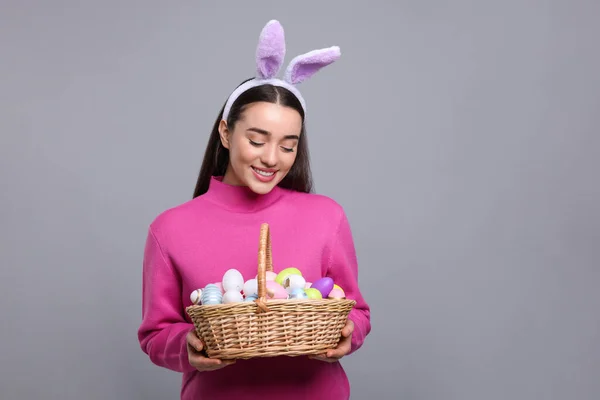 Happy Woman Bunny Ears Headband Holding Wicker Basket Painted Easter — Zdjęcie stockowe