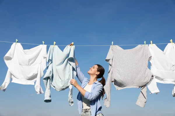 Mavi Gökyüzüne Karşı Kuruduğu Için Çamaşır Ipiyle Çamaşır Asan Kadın — Stok fotoğraf