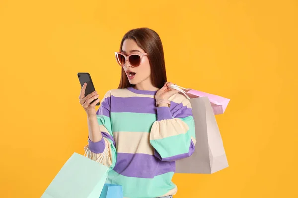 Mujer Joven Sorprendida Con Bolsas Compras Mirando Teléfono Inteligente Sobre —  Fotos de Stock