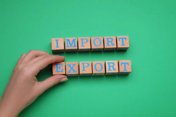 Woman Making Words Import Export Wooden Cubes Green Background Top — Stock Photo, Image