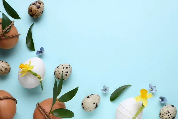 Yeşil Yapraklarla Süslenmiş Paskalya Yumurtaları Açık Mavi Arka Planda Çiçekler — Stok fotoğraf