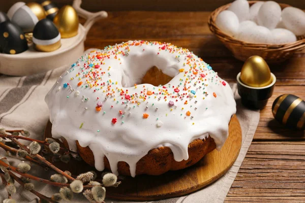 stock image Delicious Easter cake decorated with sprinkles near eggs and willow branches on wooden table, closeup