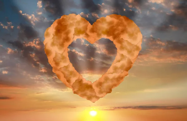 Picturesque sunset with heart formed from clouds in sky