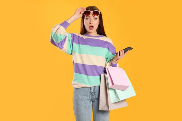 Meglepett Fiatal Bevásárló Táskák Okostelefon Sárga Háttérrel Nagy Üzlet — Stock Fotó