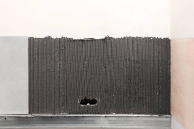 Duvara kiremit ve soket delikleri kurmak için yapıştırıcı karışımı, yakın plan