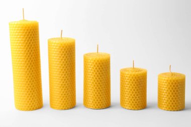 Stylish elegant beeswax candles on white background