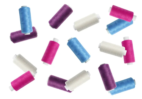 stock image Many colorful sewing threads falling on white background