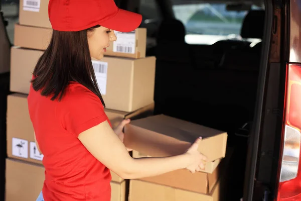 stock image Courier taking parcel from delivery van outdoors