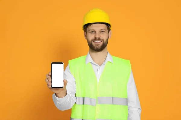 Man Reflective Uniform Showing Smartphone Orange Background — Stock Photo, Image