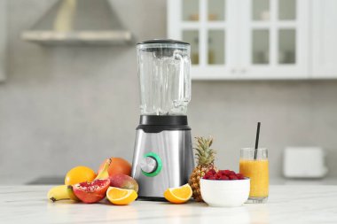 Lezzetli smoothie, blender ve malzemeler beyaz mermer masa üzerinde