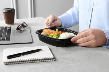 Ofis çalışanı iş yerinde öğle yemeği yiyor, yakın plan.