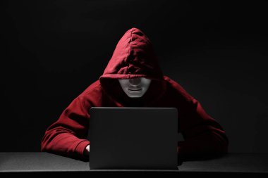 Hacker karanlık odada dizüstü bilgisayarla çalışıyor. Siber saldırı