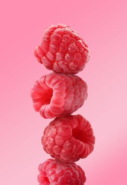 Pembe arka planda bir yığın olgun ahududu.