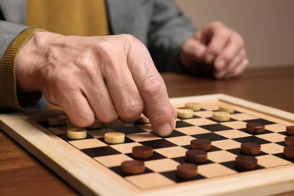 Playing Checkers Senior Man Thinking Next Move Wooden Table Closeup — Stock Photo, Image