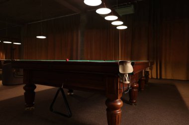 İçerideki bilardo masasında kırmızı tebeşir parçası.
