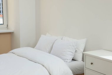 White soft pillows on cozy bed in room