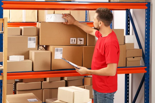 Post Office Worker Clipboard Checking Parcels Rack Indoors — Stock Photo, Image