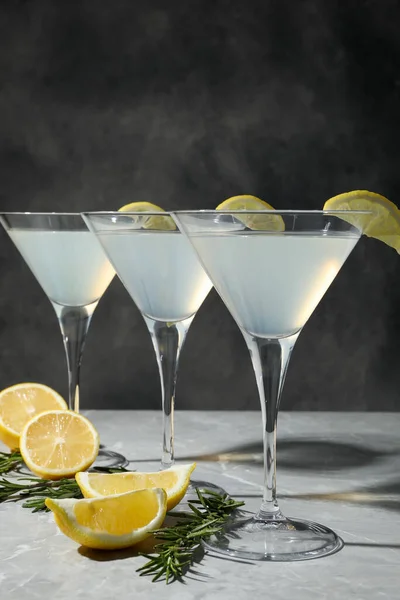 马提尼酒杯 新鲜鸡尾酒 柠檬片和迷迭香装饰在浅灰质感桌子上 — 图库照片