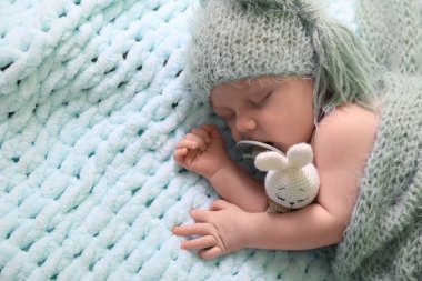 Emziği açık mavi battaniyenin üstünde uyuyan yeni doğmuş şirin bir bebek. Metin için boşluk