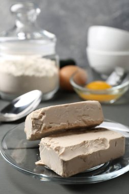 Sıkıştırılmış maya, yumurta ve un gri ahşap masada.