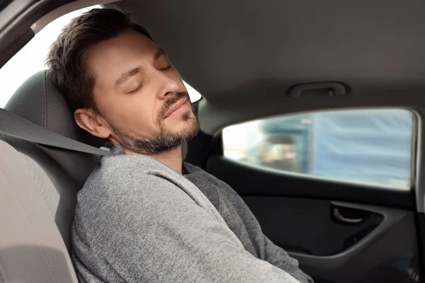 疲れハンサムな男寝ていますで彼の現代的な車 — ストック写真