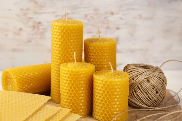 Stylish elegant beeswax candles, wax sheets and twine on table