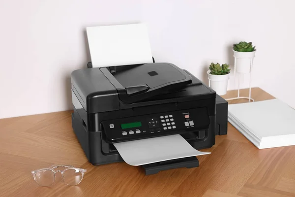 Stock image Modern printer with paper on wooden table indoors