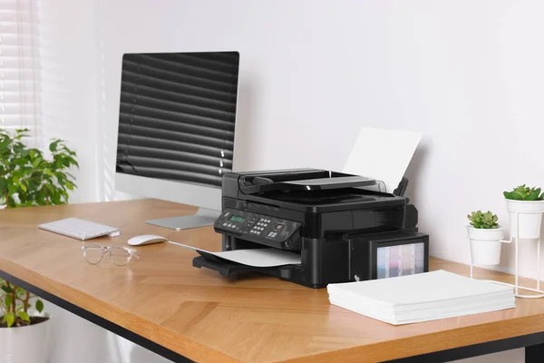办公室的木制桌子上有近于计算机的现代打印机 — 图库照片